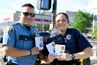 law enforcement officers distribute brochures with OLI safety tips for drivers